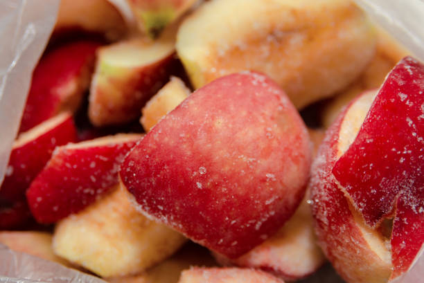 pommes coupées en tranches rouges congelées dans un gros plan de paquet - apple red fruit water photos et images de collection