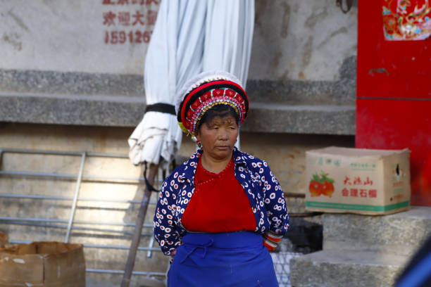 a woman of an ethnic minority of yunnan with her traditional clothes in the market of zhoucheng village, dali, yunnan, china - hani imagens e fotografias de stock