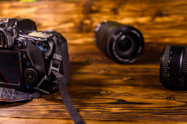 istock Modern dslr camera and lenses on wooden table 1145833098