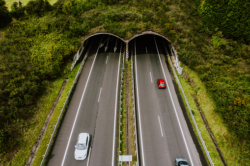 Aerial view of highway tunnel in mountains.