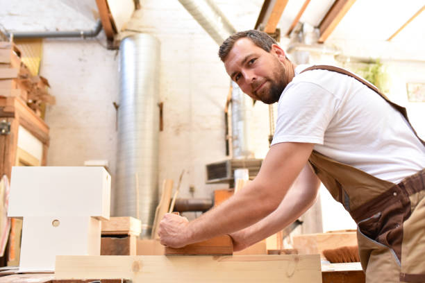 istock carpenter works in a joinery - workshop for woodworking and sawing 1145835311