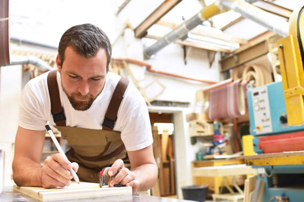 istock carpenter works in a joinery - workshop for woodworking and sawing 1145835433