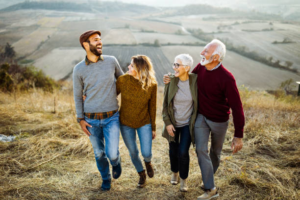 istock Happy couples talking while walking embraced in autumn day on the field. 1145835519