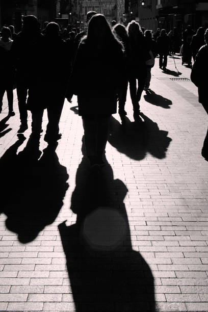 istock People walking on the street. Urban crowd in backlight 1145836482