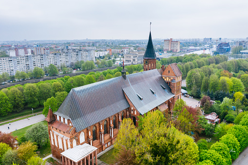 Aerial cityscape of Kant Island in Kaliningrad. Kant cathedral in the centre of the shot. The city's iconic Gothic-style Lutheran cathedral, started in 1333 and completed over the course of the 14th century in the red brick which punctuates so much of Hanseatic architecture, has had to bounce back from some serious setbacks over the centuries. WW2 saw the cathedral more thoroughly destroyed, this time by Allied air raids, and it remained in ruins until 1992 when a huge rebuilding project got underway.