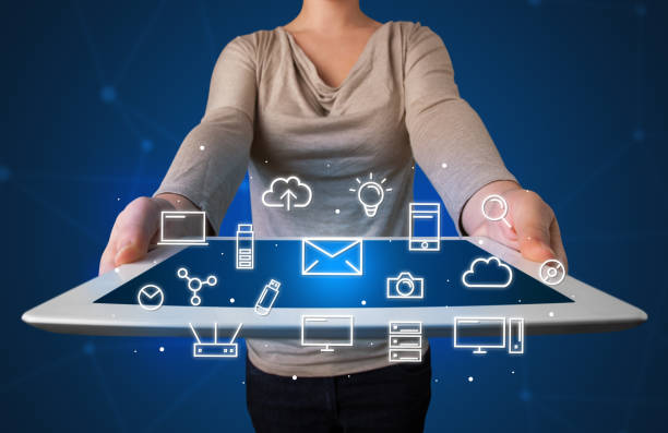 istock Woman holding tablet with media graphics 1145839375