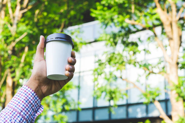 Close up hand man holding coffee paper cup.