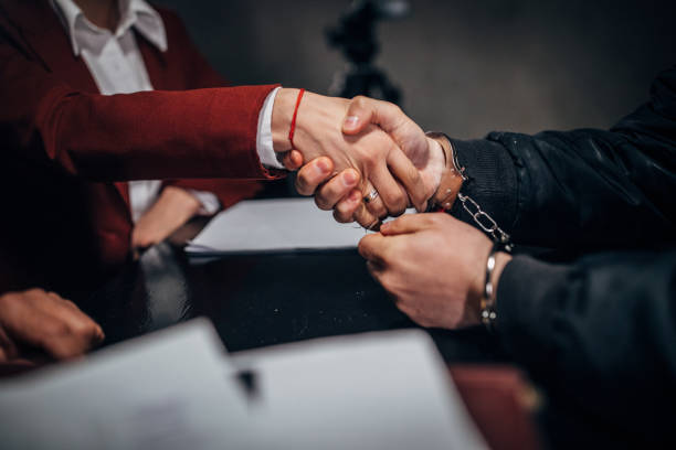 istock Arrested man with handcuffs shaking hand with lawyer 1145840204