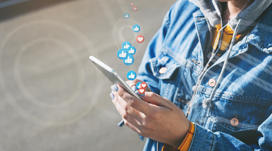 Young woman watches live stream while walking down city street