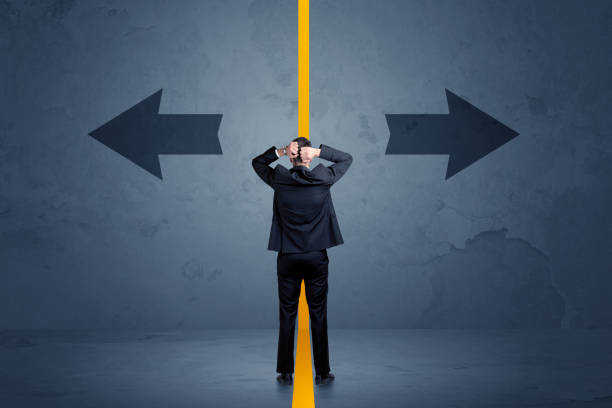 istock Business person choosing between two options separated by a yellow border arrow 1145844061