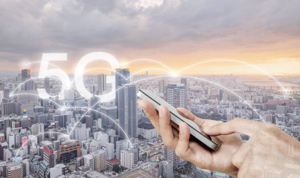 istock Hand using mobile smart phone, and wireless network connection technology in the city, with 5g internet networking sign 1145845417
