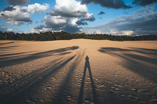 Long shadows of two people seen in sand dunes (the Netherlands).