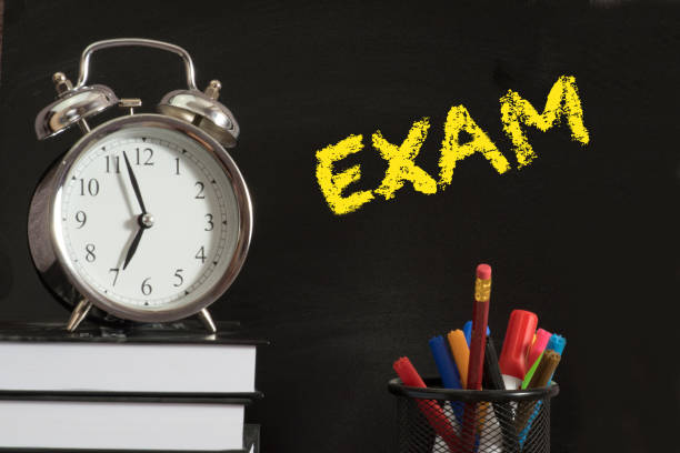 istock An alarm clock, school books and blackboard with the word exam 1145847568