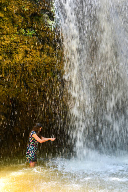Young woman in waterfall.