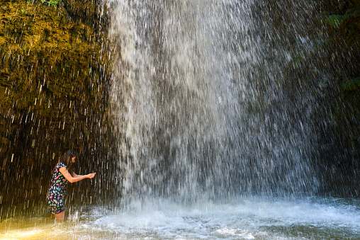 Young woman in waterfall.