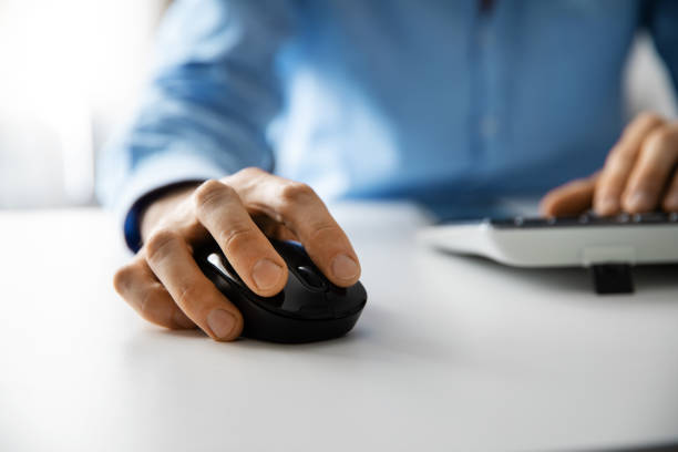 istock white collar work - man working with desktop computer in office closeup of hand clicking mouse 1145848243