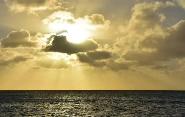 Beautiful sun shining down through the clouds over the ocean in Aruba.