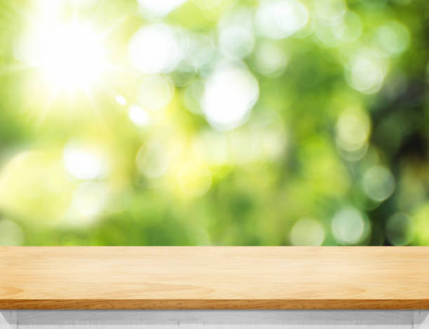 istock Empty wood plank table top with blur tree in park with bokeh light at background,Mock up template for display of your design,Banner for advertise of product 1145852286