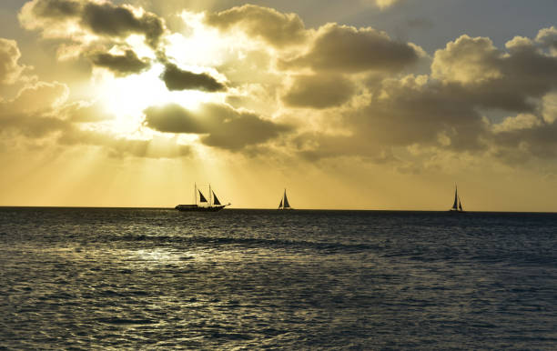 tramonto mozzafiato sull'oceano ad aruba - sailing sailboat sunset aruba foto e immagini stock