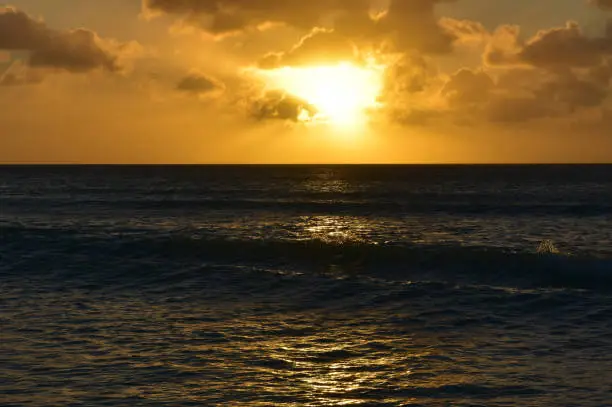 Small waves in the glistening ocean at sunset in Aruba.
