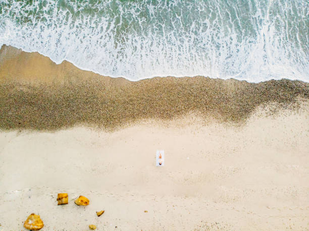 istock Woman sunbathing on the beach 1145854148
