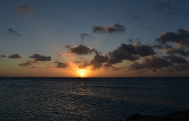 istock Burning Orange Sunset with Dark Clouds over the Ocean in Aruba 1145854495
