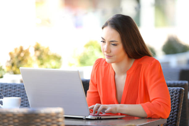 istock Serious woman is using a laptop in a coffee shop 1145855850