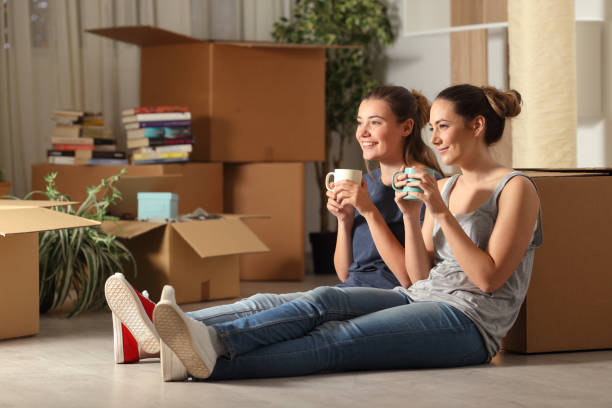istock Happy roommates moving home resting drinking coffee 1145856101