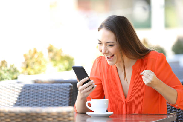 istock Excited woman checking smart phone content in a coffee shop 1145856241