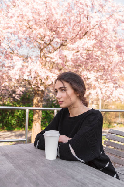 ragazza seduta sullo sfondo dell'albero di fiori rosa - bench sitting tree apple foto e immagini stock