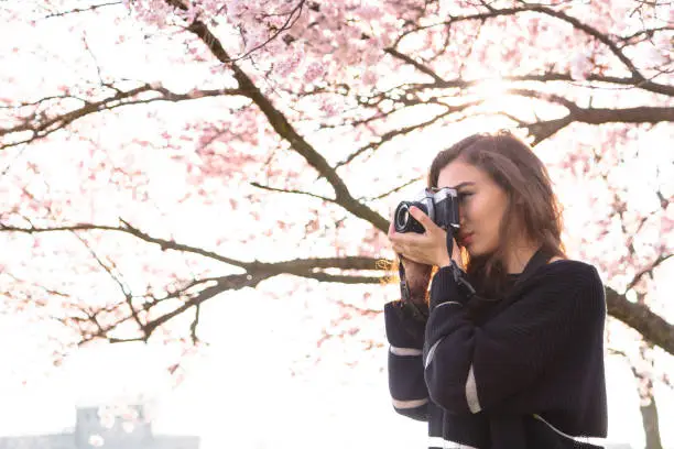 Photo of Girl makes picture while standing under tree