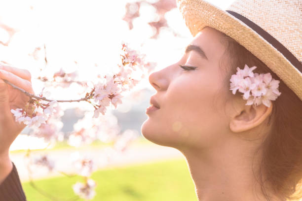 istock Beautiful girl in straw hat sniffs blossom branch 1145860274