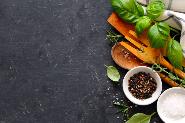 istock Wooden spoon and knife with ingredients on dark background. 1145860980