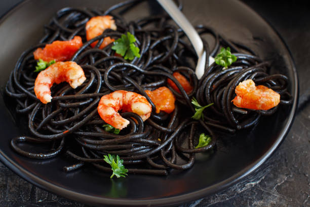 istock Squid ink pasta with prawns and tomatoes 1145861669