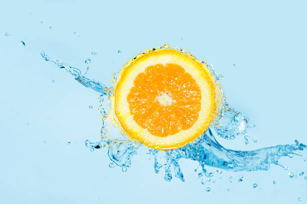 Fresh orange dropped into water with big splash