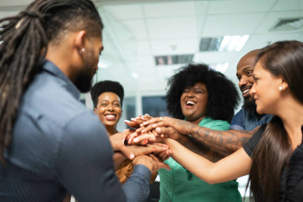 istock Business team cheering joining hands in huddle 1145862404
