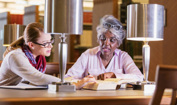 istock Two women doing research in the library together 1145862583