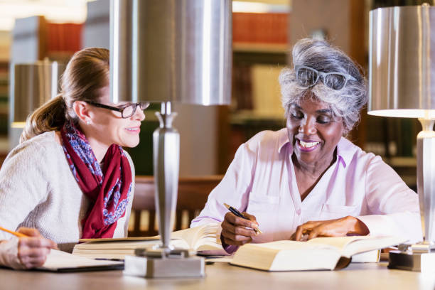 istock Two women doing research in the library together 1145862586