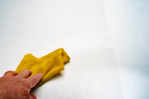 Woman cleaning and wiping the table with microfiber cloth duster in the living room. Woman doing chores at home. Housekeeping concept.