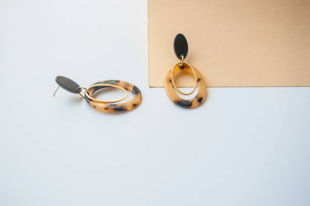 istock Earrings on beige and brown color background. 1145865780