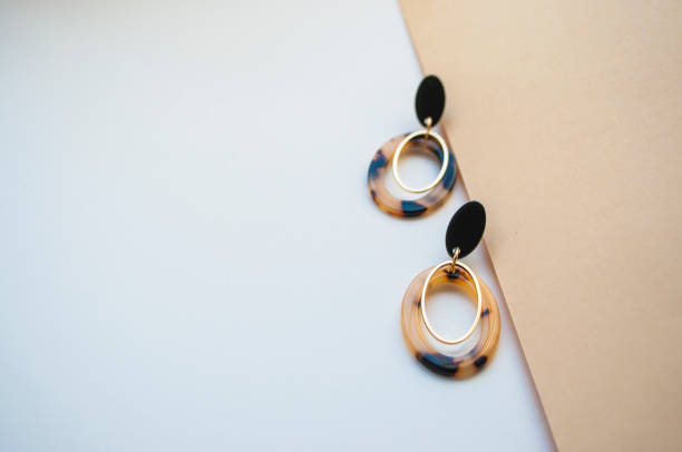 istock Earrings on beige and brown color background. 1145865781