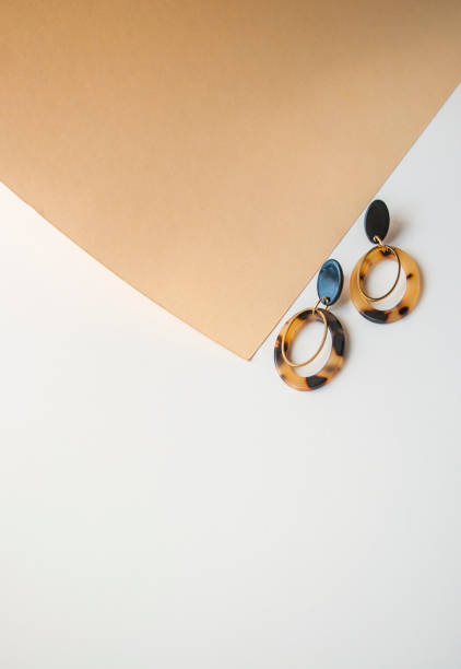 istock Earrings on beige and brown color background. 1145865788