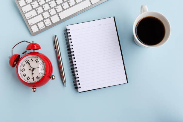istock Top View of Office Desk With Alarm Clock 1145866746