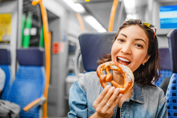 woman eating pretzel while traveling by train