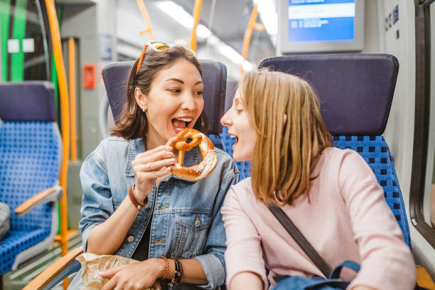 istock woman eating pretzel while traveling by train 1145867124