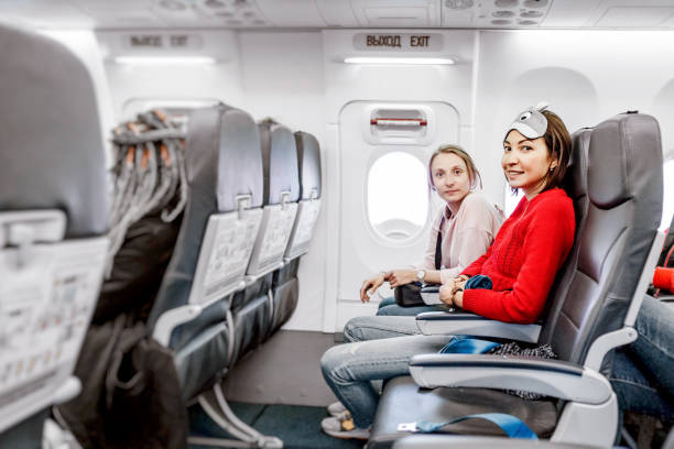 istock Happy Girlfriends traveling by plane together, air flight passengers 1145867126