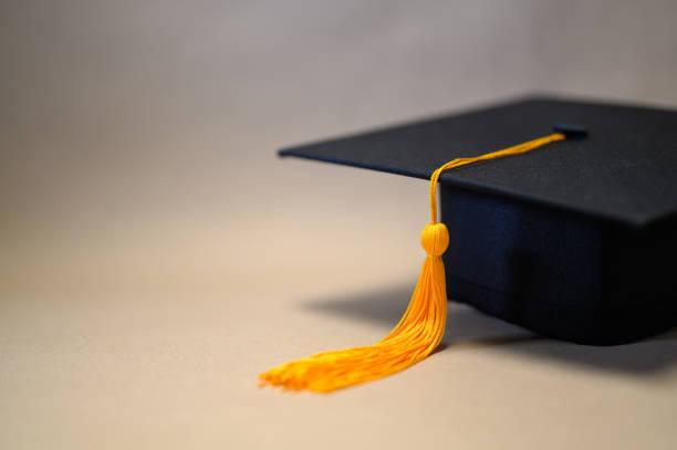 cappello da laurea nero posto su carta marrone - tocco accademico foto e immagini stock