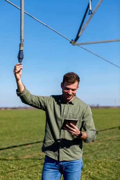 istock Young farmer standing in wheat field and setup irrigation system on tablet. 1145870617