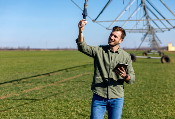 istock Young farmer standing in wheat field and setup irrigation system on tablet. 1145870690