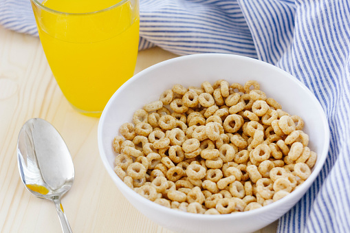 Nestlé cheerios cereals on breakfast table with orange juice and spoon